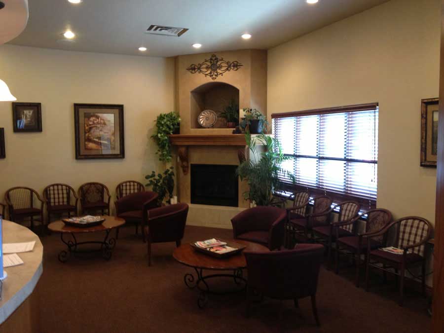 Comfortable waiting room with armchairs, fireplace, and warm lighting